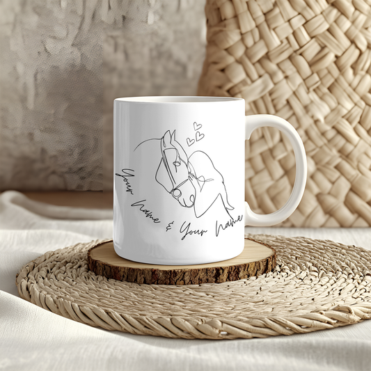 White mug featuring line art of two people kissing with small hearts above them, placed on a woven mat. The text below reads & your name & your name," making it perfect for adding a personalisierbar touch.