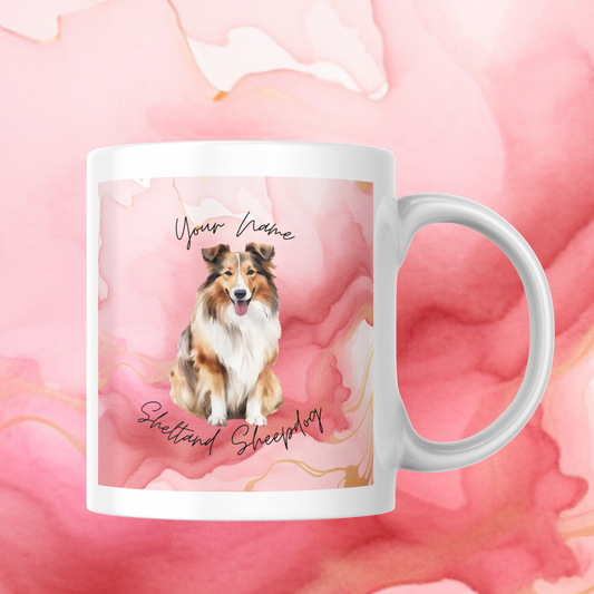 Personalisierte Tasse mit Shetland Sheepdog Motiv und rosa-goldenem Aquarell-Hintergrund. Individuelle Namensgestaltung möglich – ideales Geschenk für Hundefans.
