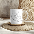 Bild in Galerie-Betrachter laden, White mug featuring line art of two people kissing with small hearts above them, placed on a woven mat. The text below reads & your name & your name," making it perfect for adding a personalisierbar touch.
