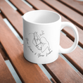 Bild in Galerie-Betrachter laden, White mug featuring line art of two people kissing with small hearts above them, placed on a woven mat. The text below reads "your name & your name," making it perfect for adding a personalisierbar touch.
